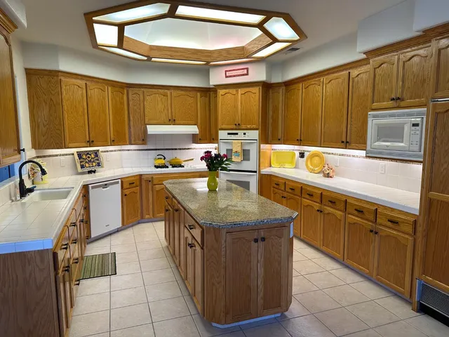 a kitchen with a sink a stove cabinets and a dining table