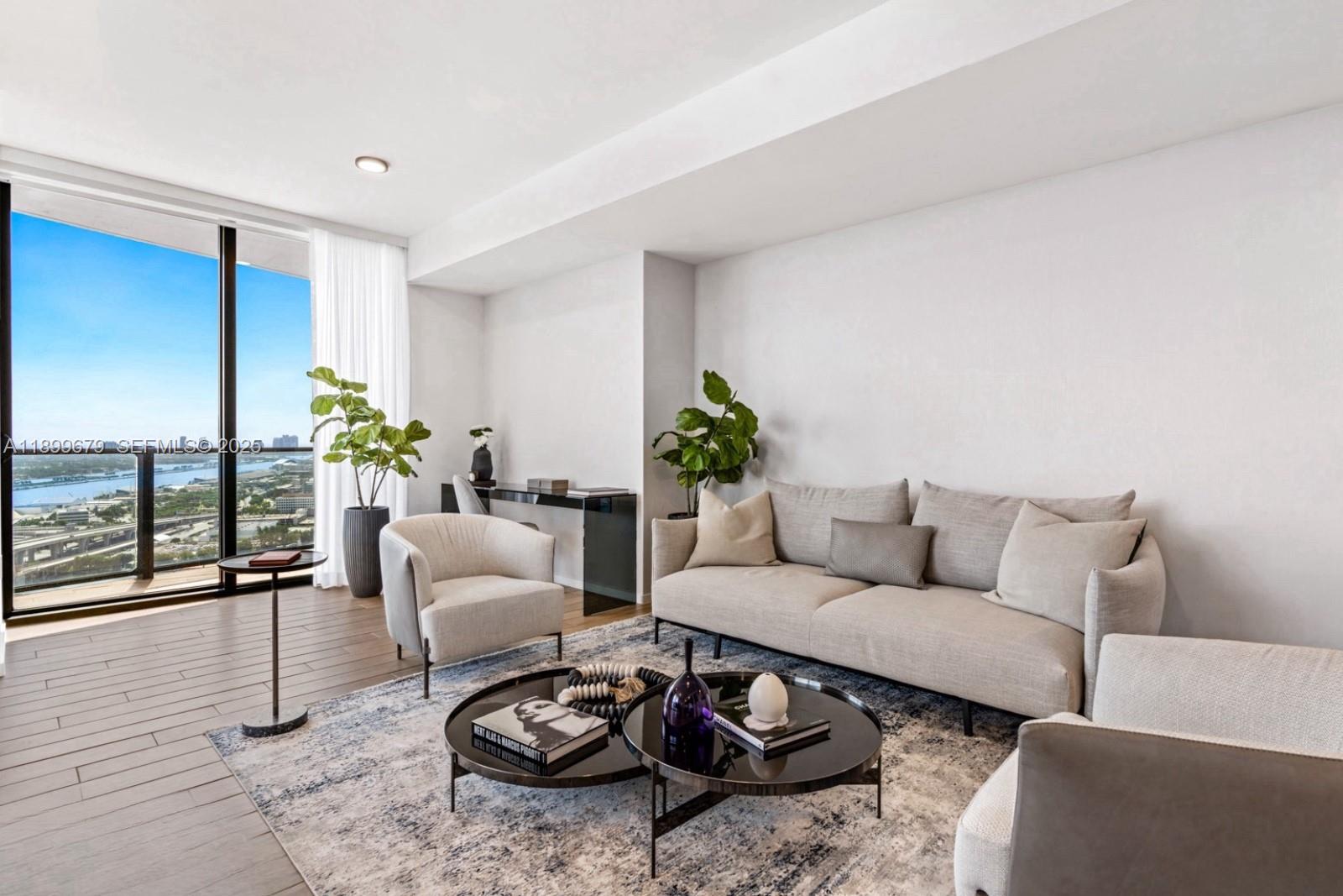 398 Northeast 5th Street, Unit 4409 Miami, FL 33132 - Photo 2 of 30 a living room with furniture a rug and a floor to ceiling window