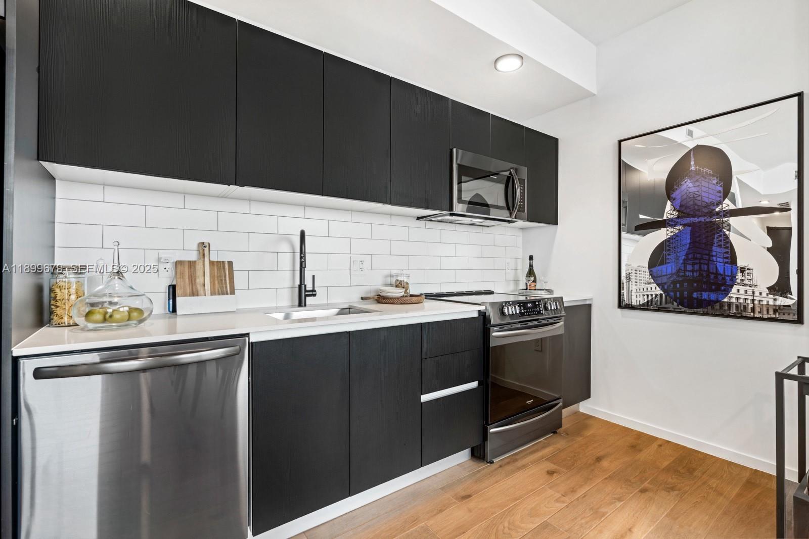 398 Northeast 5th Street, Unit 4409 Miami, FL 33132 - Photo 6 of 30 a kitchen with stainless steel appliances a sink and a refrigerator