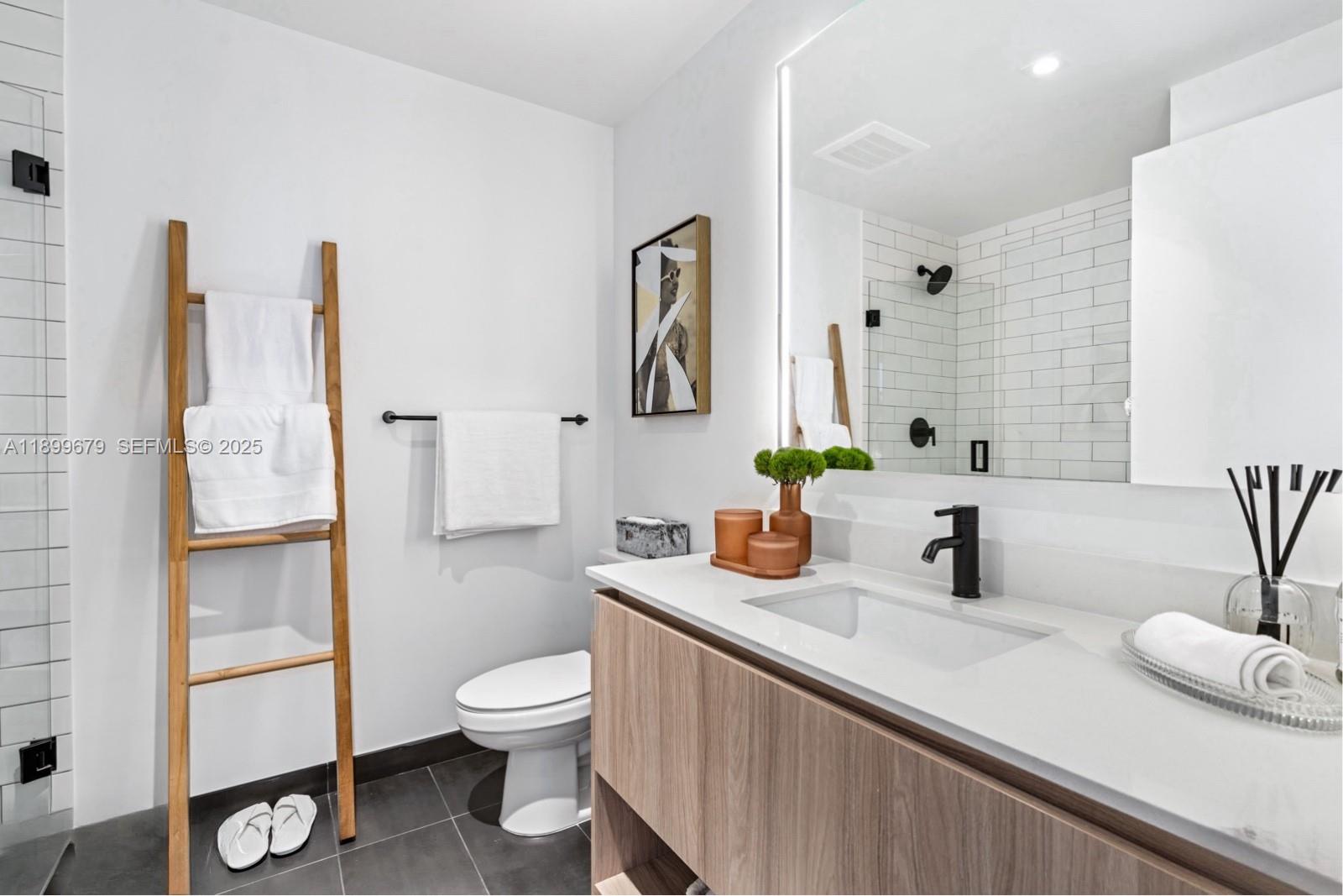 398 Northeast 5th Street, Unit 4409 Miami, FL 33132 - Photo 10 of 30 a bathroom with a toilet sink and mirror