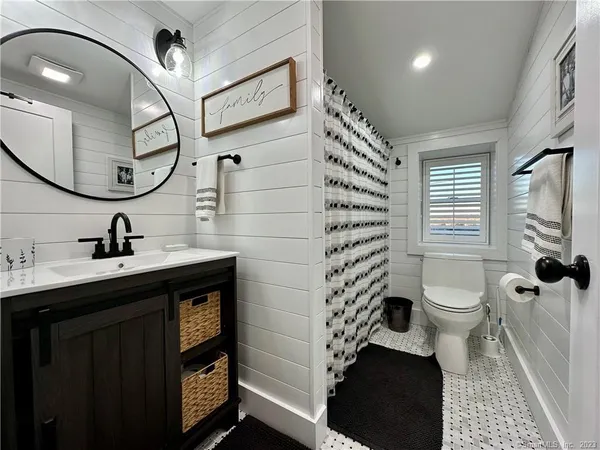 a bathroom with a toilet a sink and a mirror