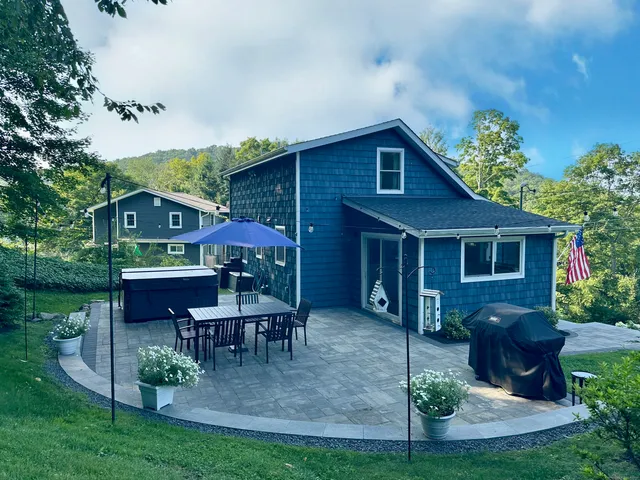a view of house with a yard and patio