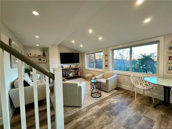 a living room with furniture flat screen tv and couches