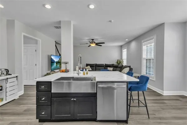 a kitchen with stainless steel appliances kitchen island granite countertop a table and chairs in it