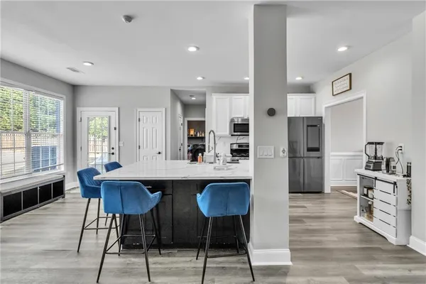 a large kitchen with kitchen island a dining table and chairs