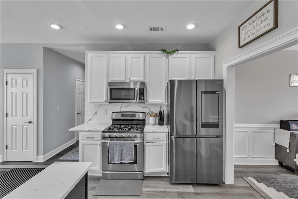 2800 Barimore Place Dacula, GA 30019 - Photo 18 of 51 a kitchen with stainless steel appliances a refrigerator a stove and white cabinets