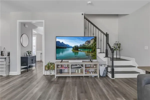 a living room with furniture and a wooden floor