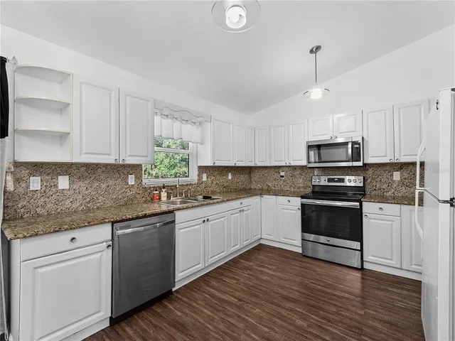 a kitchen with granite countertop wooden cabinets and stainless steel appliances