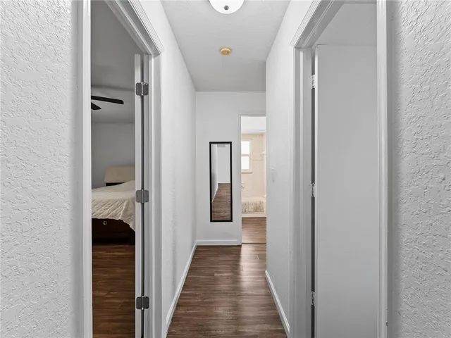 a view of a hallway with wooden floor and staircase