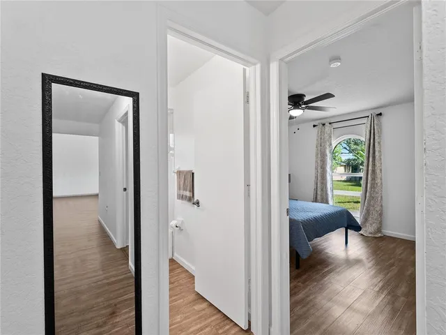 a view of a hallway with wooden floor and furniture in a room