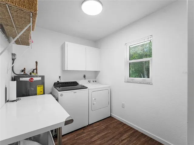 a kitchen that has a sink and a stove with wooden floor