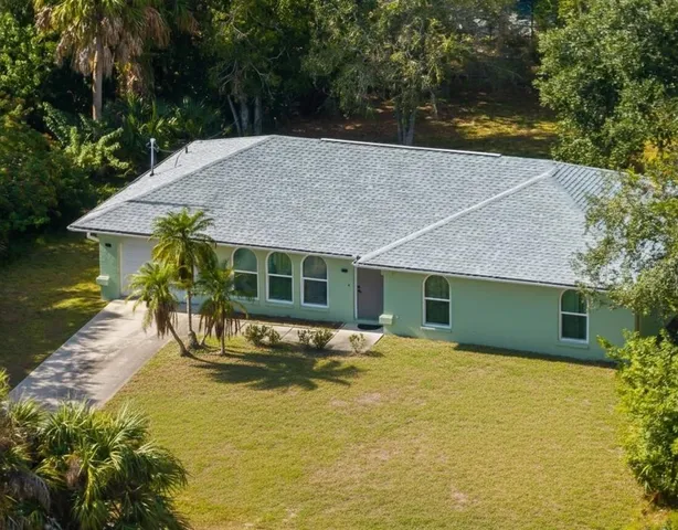 an aerial view of a house with yard and green space
