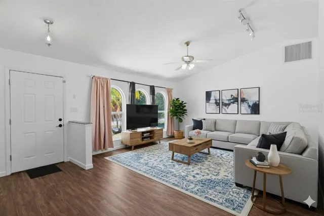 a living room with furniture and wooden floor