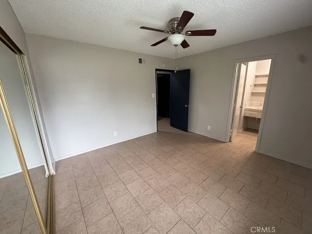 a view of an empty room and a bathroom with a sink