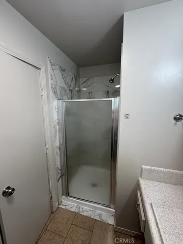 a bathroom with a granite countertop shower and a sink
