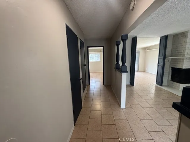 a hallway with a black white checkered floor and a flat screen tv