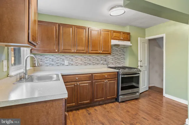 a kitchen with granite countertop a sink and a stove top oven