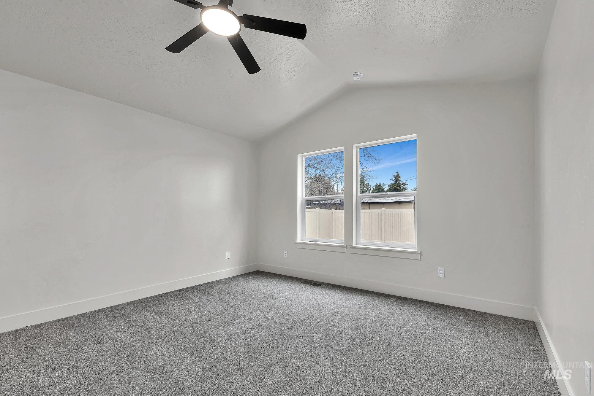 1130 Velvet Loop Wilder, ID 83676 - Photo 18 of 35 Room featuring vaulted ceilings, gray carpet flooring, and white walls