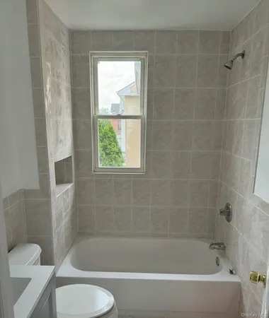 a bath tub sitting next to a white toilet and a shower