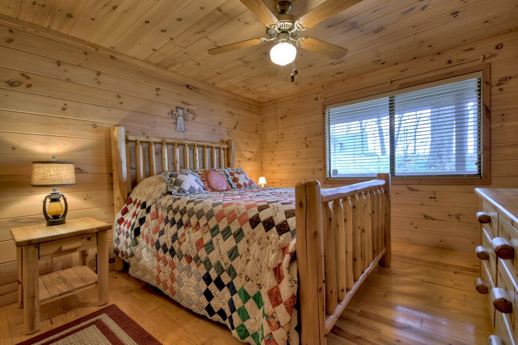 1285 Walnut Ridge Ellijay, GA 30536 - Photo 16 of 38 a bed sitting in a bedroom next to a window