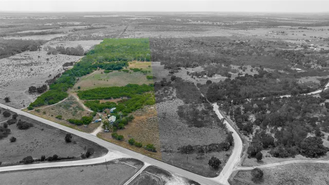 a view of a dry yard with wooden fence