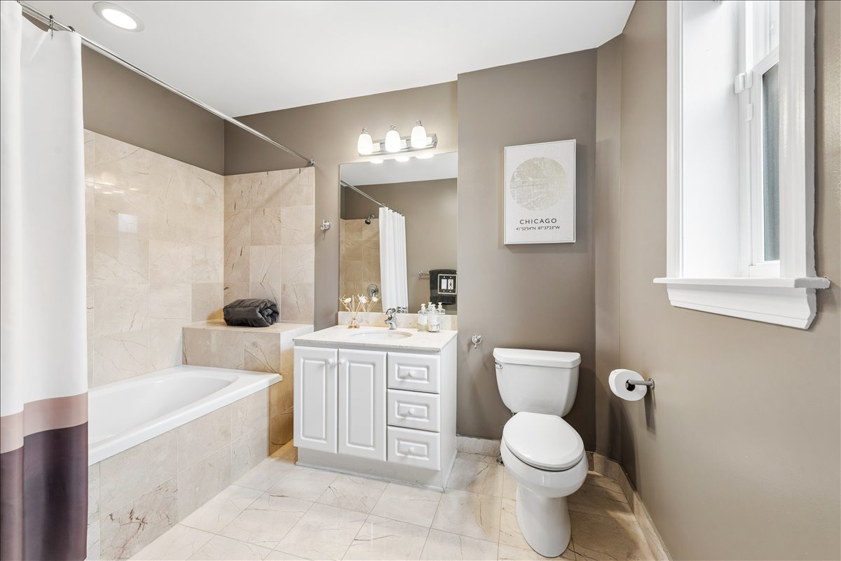 561 West Briar Place, Unit 305 Chicago, IL 60657 - Photo 17 of 23 a bathroom with a toilet a sink a tub and mirror