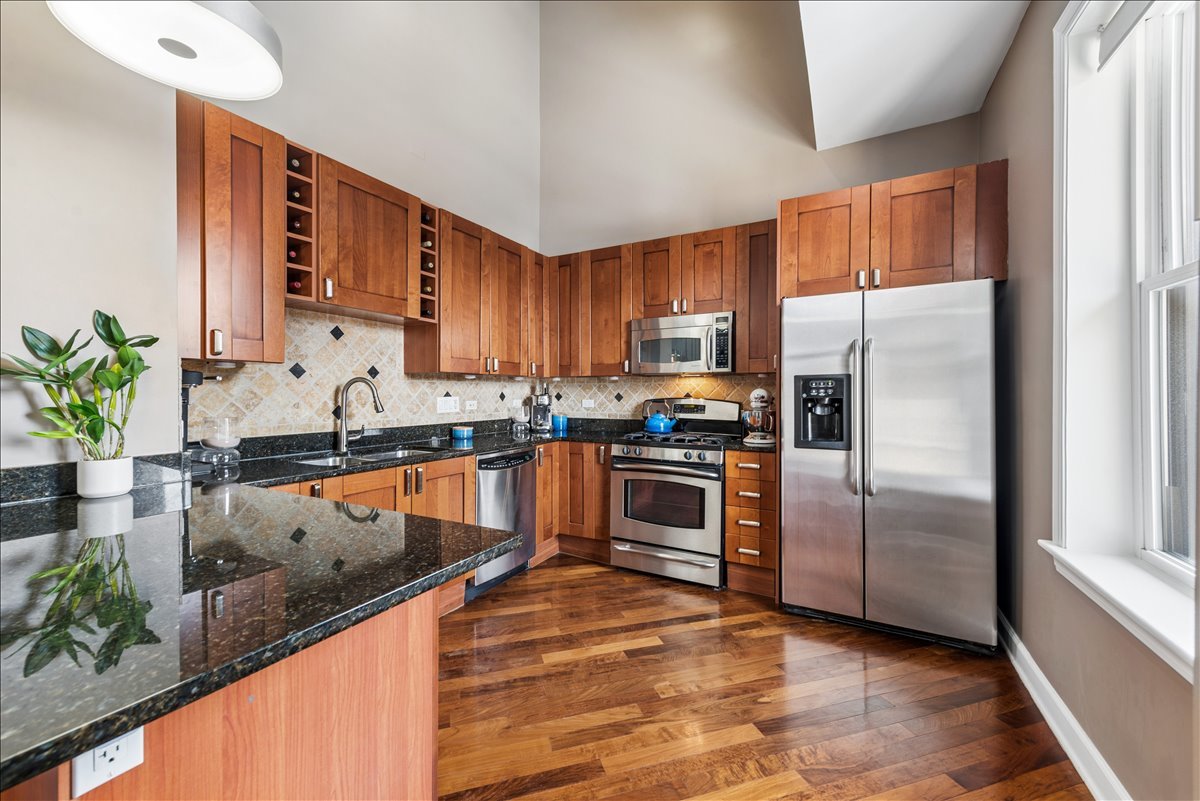 561 West Briar Place, Unit 305 Chicago, IL 60657 - Photo 7 of 23 a kitchen with granite countertop stainless steel appliances a counter top space and cabinets