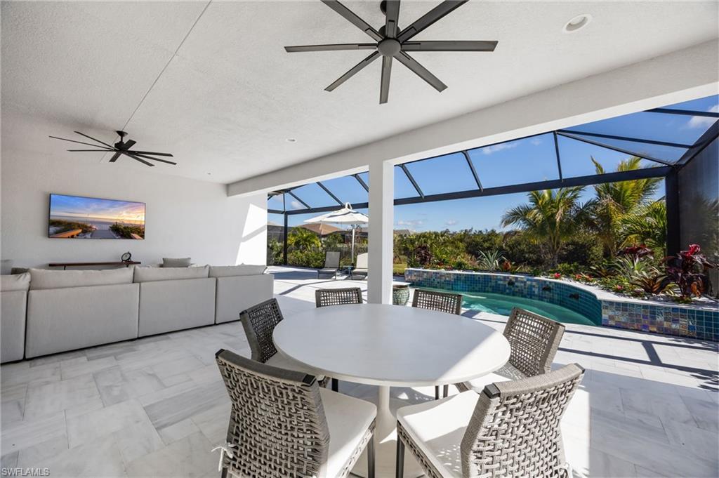 12128 Eucalyptus Way Naples, FL 34120 - Photo 29 of 47 The extended covered living area and stone travertine paver pool deck elevate this outdoor living space and set the stage to enjoy indoor outdoor living!