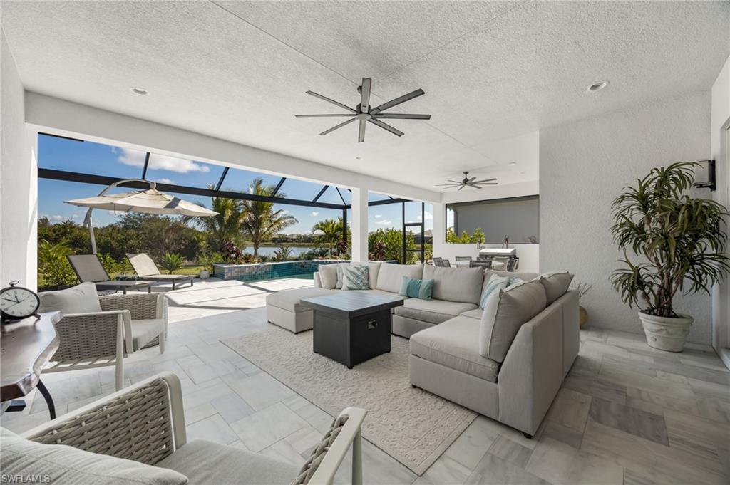 12128 Eucalyptus Way Naples, FL 34120 - Photo 30 of 47 The extended covered living area and stone travertine paver pool deck elevate this outdoor living space and set the stage to enjoy indoor outdoor living!