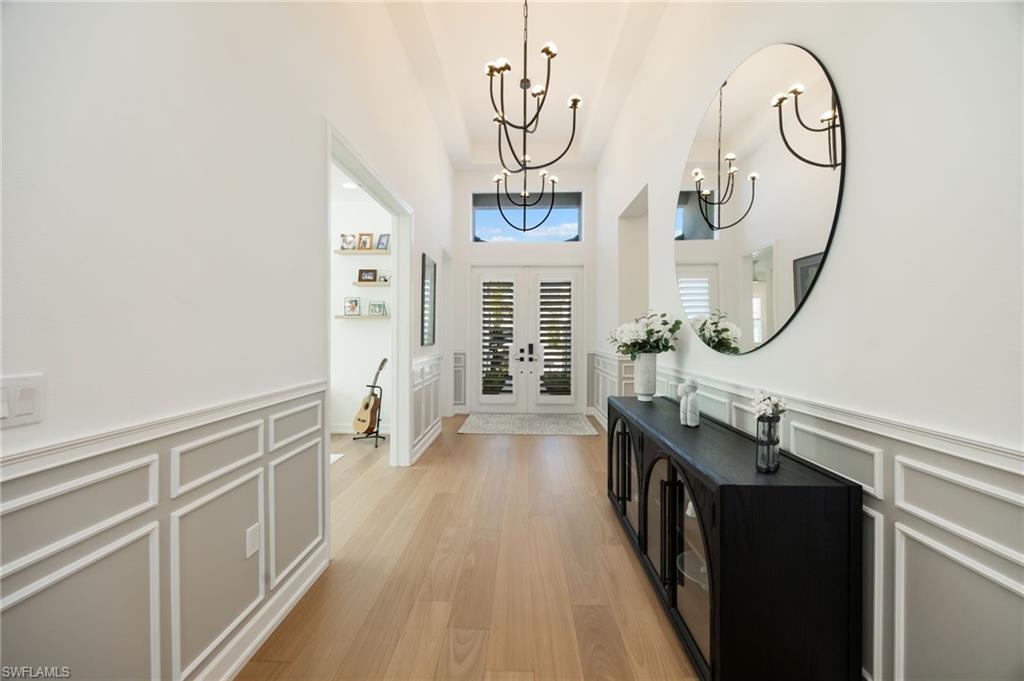 12128 Eucalyptus Way Naples, FL 34120 - Photo 6 of 47 First impressions! High ceilings, grand scale lighting fixtures, wood flooring, and custom wall trim treatments set a warm and welcoming tone from the moment you walk through the door.