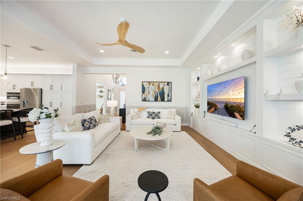 12128 Eucalyptus Way Naples, FL 34120 - Photo 7 of 47 The custom wall feature in the great room feels grounded and inviting. Impact sliders lead out to the outdoor living area - this is seamless indoor/outdoor living!