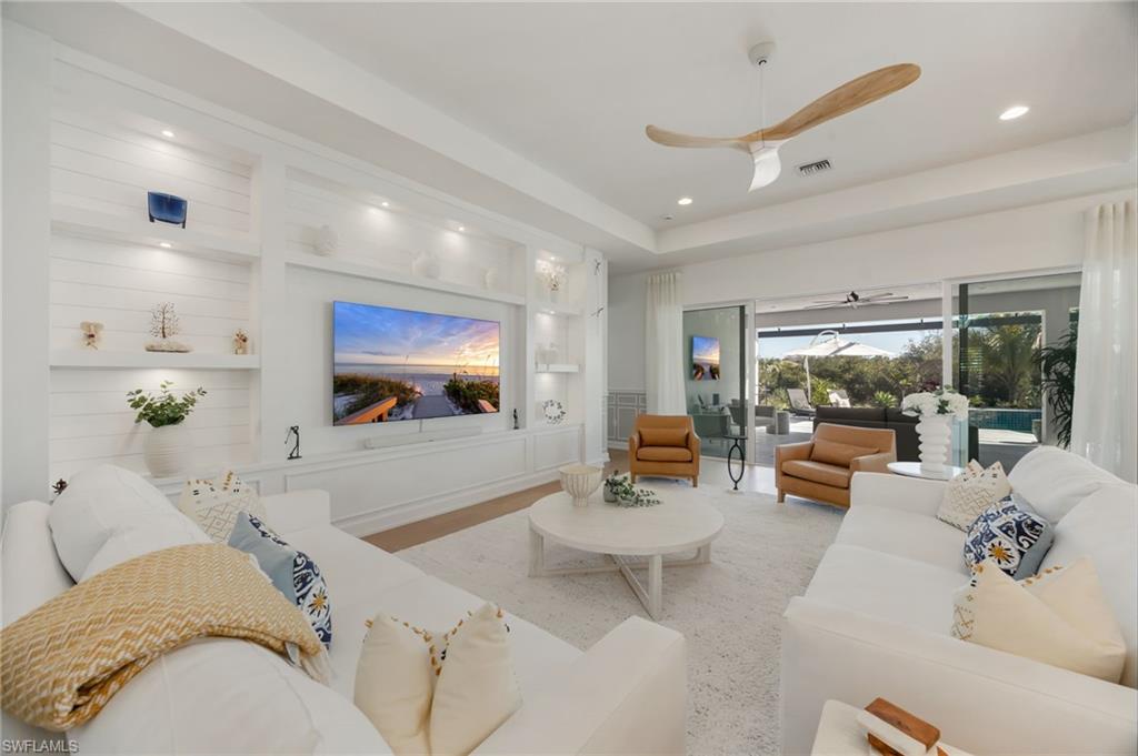 12128 Eucalyptus Way Naples, FL 34120 - Photo 8 of 47 The custom wall feature in the great room feels grounded and inviting. Impact sliders lead out to the outdoor living area - this is seamless indoor/outdoor living!