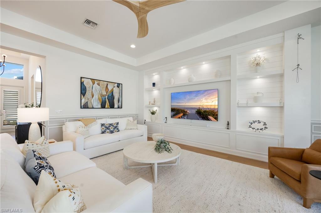 12128 Eucalyptus Way Naples, FL 34120 - Photo 9 of 47 The custom wall feature in the great room feels grounded and inviting. Impact sliders lead out to the outdoor living area - this is seamless indoor/outdoor living!