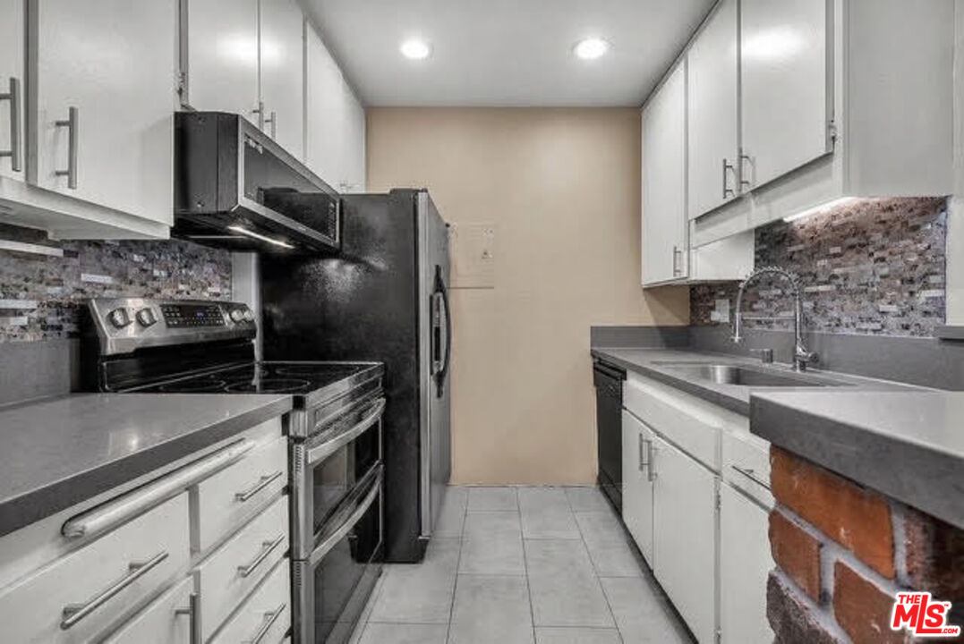7740 Redlands Street, Unit G3092 Playa del Rey, CA 90293 - Photo 16 of 37 a kitchen with stainless steel appliances granite countertop a sink stove and refrigerator
