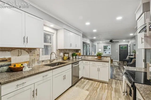 a kitchen with stainless steel appliances granite countertop a sink stove and cabinets