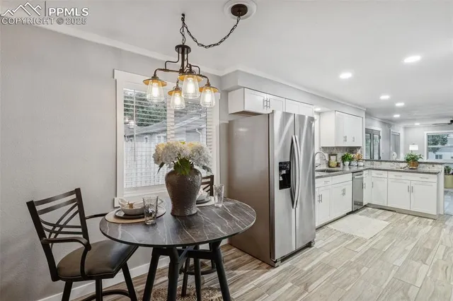 a kitchen with stainless steel appliances a dining table chairs and granite counter tops