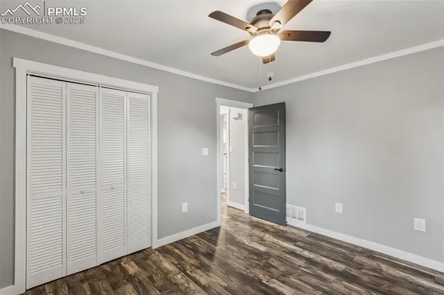 an empty room with closet and a ceiling fan