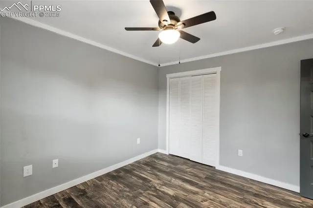 an empty room with a ceiling fan and wooden floor