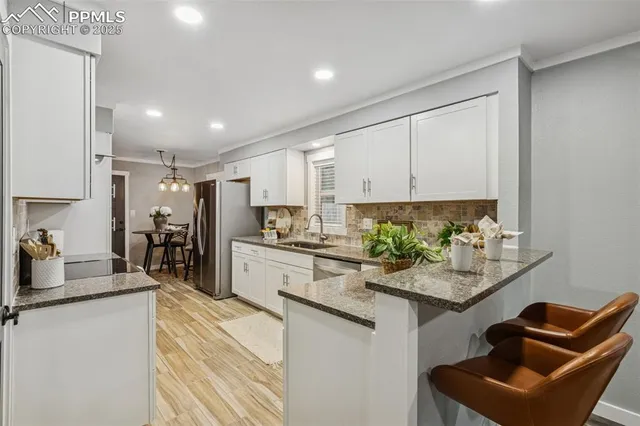 a kitchen with stainless steel appliances granite countertop sink stove refrigerator and cabinets