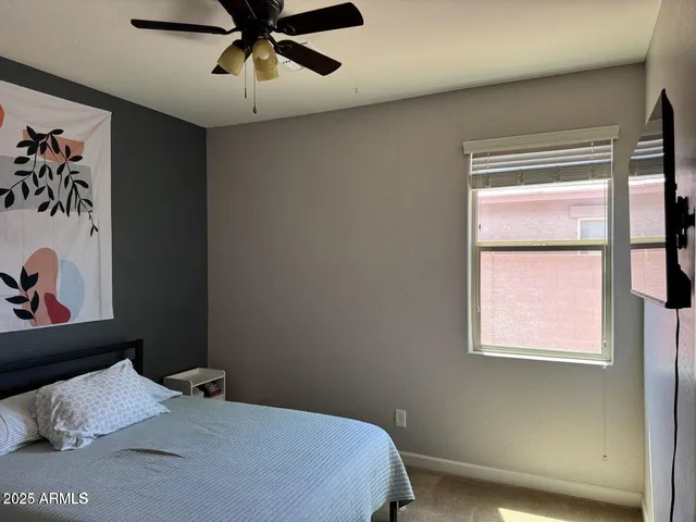 a bedroom with a bed and a refrigerator