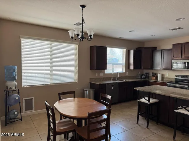 a kitchen with a stove a sink a kitchen island with a dining table and chairs