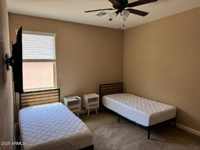 a bedroom with a bed window and a ceiling fan