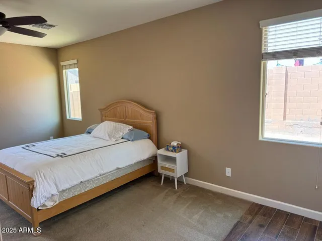 a bed sitting in a spacious bedroom next to a window