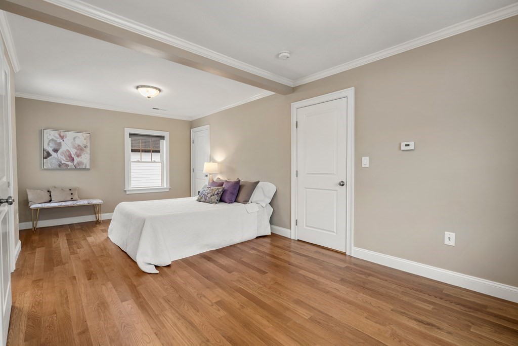 22 Myrtle Street Watertown, MA 02472 - Photo 12 of 18 a bedroom with a large bed and a chandelier