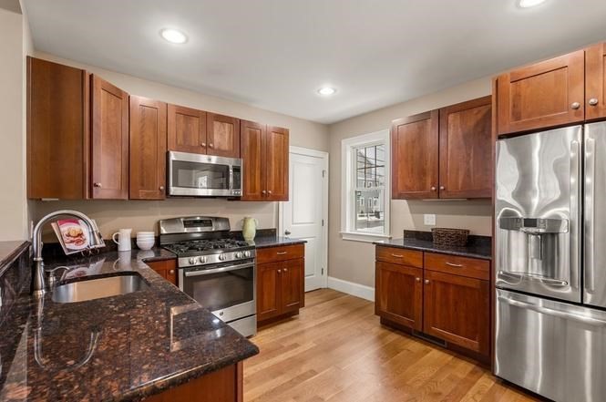 22 Myrtle Street Watertown, MA 02472 - Photo 4 of 18 a kitchen with stainless steel appliances granite countertop a stove top oven a sink dishwasher a refrigerator and cabinets with wooden floor