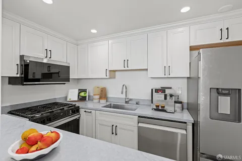 a kitchen with white cabinets and appliances