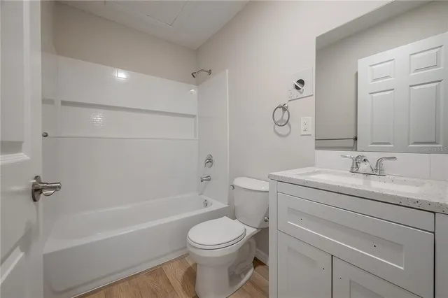 a bathroom with a granite countertop sink a toilet and shower