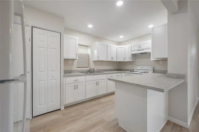 a kitchen with granite countertop white cabinets and white appliances