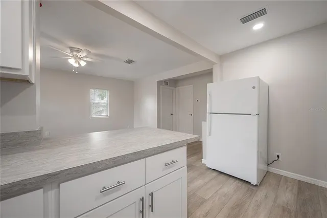 a kitchen with a refrigerator a sink and a stove top oven