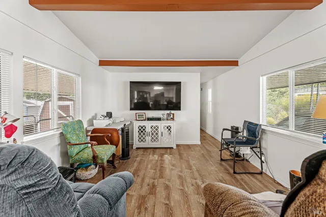 a living room with furniture a flat screen tv and a floor to ceiling window